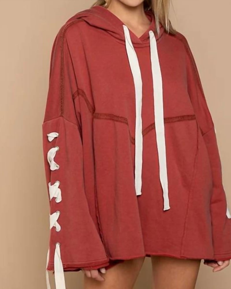Front of a model wearing a size L Lace Up Sleeve Hooded Sweatshirt in Carnelian Orange in Carnelian Orange by POL. | dia_product_style_image_id:327487